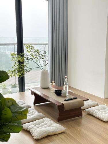 a living room with a coffee table and a large window at Hue Charm Apartment with Pool and Gym in Thôn Văn Dương
