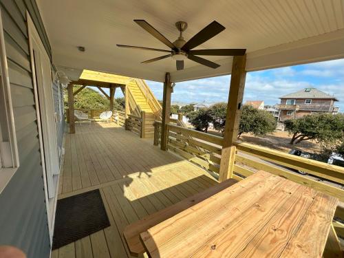 a porch with a ceiling fan and a wooden bench at Outer Banks Haven New Kitchen and New Outdoor Areas in Kitty Hawk Beach