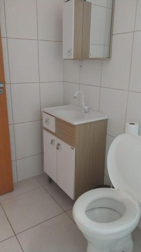un bagno con un water bianco e un lavandino di Apartamento grande a Navegantes