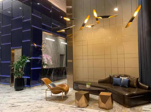 a lobby with a leather couch and a chair at 1Br Feliz apartment ThanhMyLoi in Ho Chi Minh City