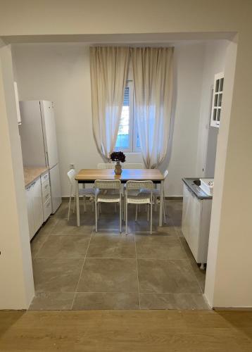 Una cocina con mesa y sillas y una ventana. en Trosobni apartman, en Belgrado