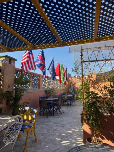 a patio with several tables and chairs and flags at RIAD ESMERALDA By Dar Ouezzani in Rabat