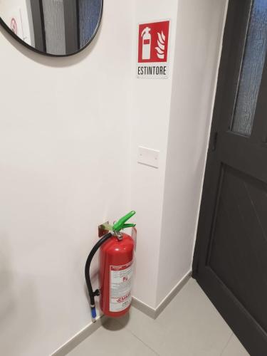 a fire extinguisher in the corner of a room at The One Malpensa Rooms in Vizzola Ticino