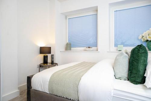 a white bedroom with a bed and two windows at Luxury Apartment - Sleeps 5 - Rose Platinum Properties in Liverpool