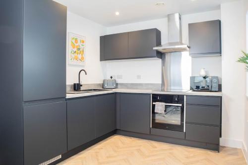 a kitchen with gray cabinets and a stove at Luxury Apartment - Sleeps 5 - Rose Platinum Properties in Liverpool