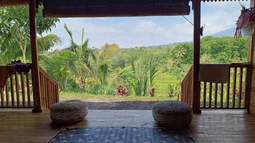 a screened porch with a view of a forest at Dedari Lodge Jatiluwih Rice fields in Jatiluwih