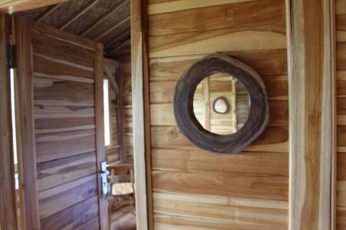 a mirror on the wall of a log cabin at Dedari Lodge Jatiluwih Rice fields in Jatiluwih