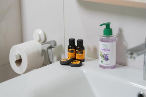 a bathroom counter with two bottles of essential oils and a roll of toilet paper at Appart Moderne Tamaris Piscine, Plage et Confort in Tamaris