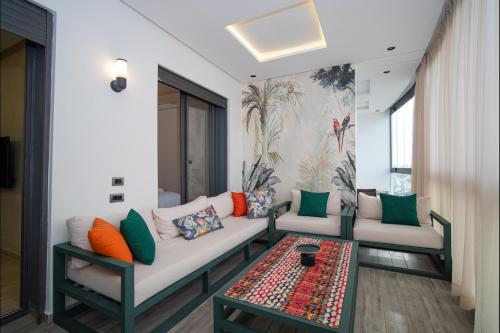 a living room with two couches and a table at Appart Moderne Tamaris Piscine, Plage et Confort in Tamaris