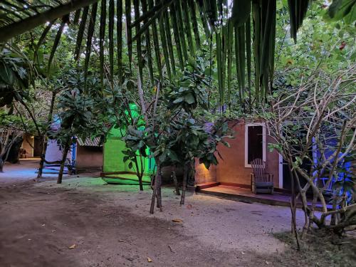 a house with trees in front of a building at By The C' Cabanas in Hikkaduwa