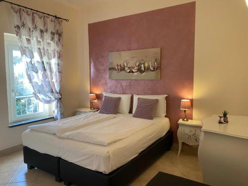 a bedroom with a large bed and a window at Betty's House in Lazise