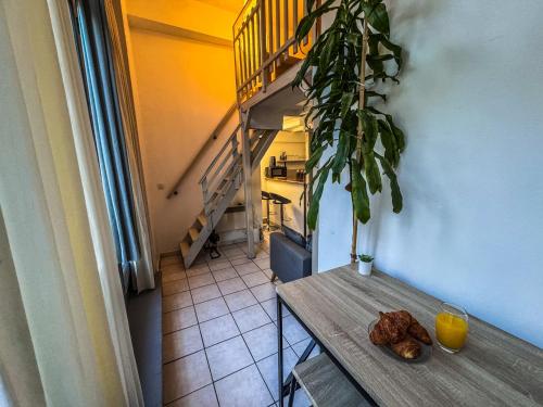 une table avec une plante et un escalier dans une pièce dans l'établissement Le Studio de la Comédie, à Montpellier