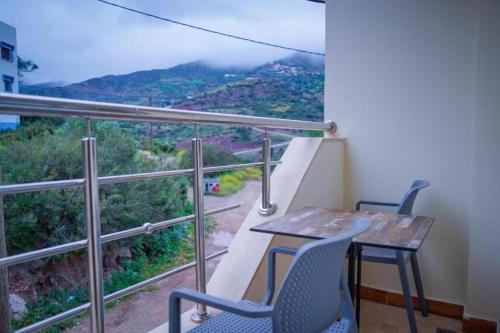 a balcony with a table and chairs and a view at hotel el amri akchour in Akchour