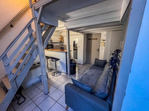 un salon avec un canapé et un escalier dans l'établissement Le Studio de la Comédie, à Montpellier