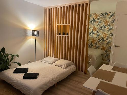 a small bedroom with a bed and a table and chairs at Appartement cosy avec jardin vue et accès à 30m de la mer in Bernières-sur-Mer