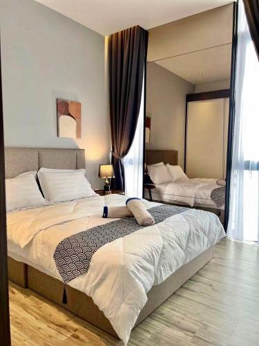 a large bedroom with two beds and a mirror at Podium apartments in Kuching