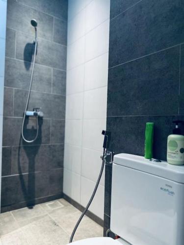 a shower in a bathroom with a toilet with a hose at Podium apartments in Kuching
