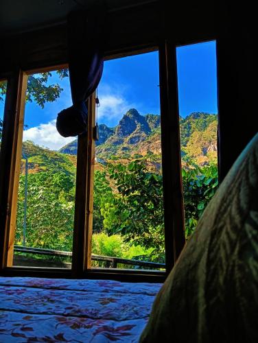 a view of a mountain from a bedroom window at Mundo Abu San Juan La laguna in San Juan La Laguna