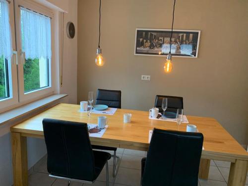 ein Esszimmer mit einem Holztisch und Stühlen in der Unterkunft Cozy Apartment - 2 BR, Spacious Kitchen, Balcony, Top Location in Hemsbach
