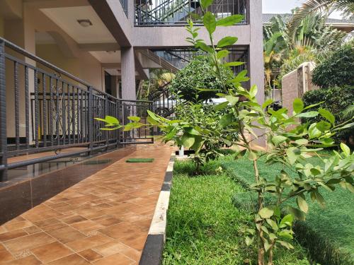 a walkway in front of a building with plants at Serene Courts Kitende in Kitende