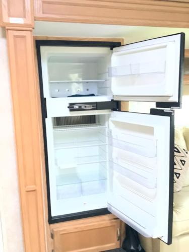 an empty refrigerator with its door open at Glamping im Wald in Mareuil-sur-Belle