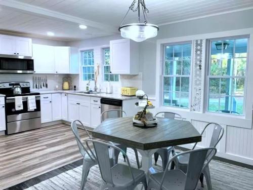 Una cocina con gabinetes blancos y una mesa y sillas. en The Honeycomb Haven l 1 Mile to Downtown Thomasville, en Thomasville