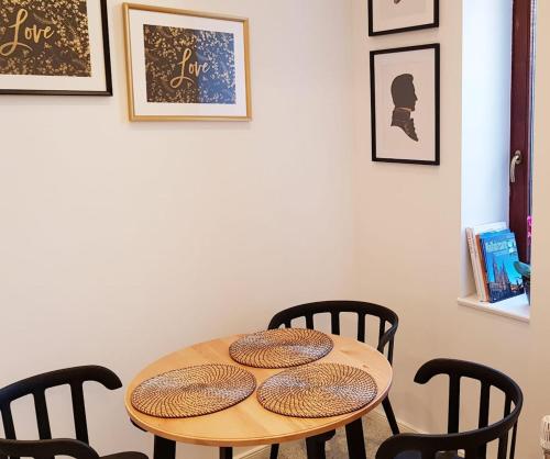 ein Holztisch mit vier Stühlen um ihn herum in der Unterkunft Green Apartment Studio L29 Neukölln in Berlin