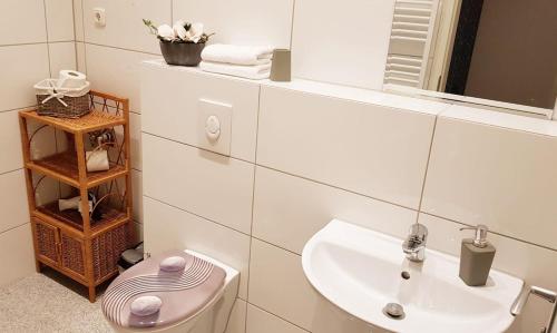 ein weißes Badezimmer mit Waschbecken und Toilette in der Unterkunft Green Apartment Studio L29 Neukölln in Berlin