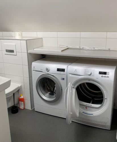 a washer and dryer under a counter in a kitchen at Forenom Hostel Gothenburg Säve in Gothenburg