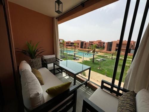 a living room with a couch and a view of a pool at Domaine de Noria Isli 2 - Magnifique 2 chambres - Vue directe sur la piscine in Marrakech