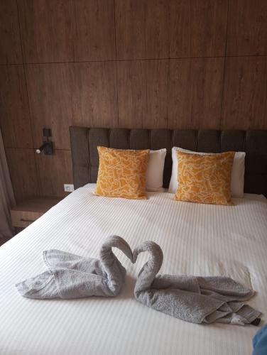 two towels in the shape of a heart on a bed at Domaine de Noria Isli 2 - Magnifique 2 chambres - Vue directe sur la piscine in Marrakech