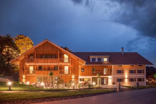 a large wooden house with lights in front of it at Hierlhof in Immenstadt im Allgäu