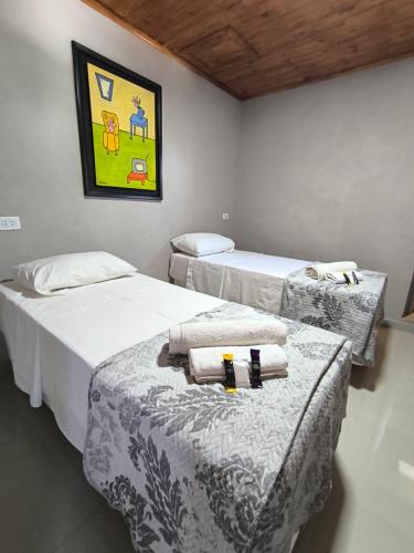 a room with three beds and a painting on the wall at La Posada de Dante in Puerto Iguazú