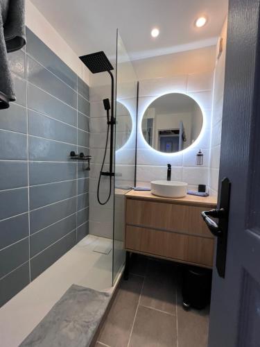 une salle de bain avec un lavabo et une douche avec un miroir dans l'établissement Charmant appartement baie Saint Tropez 6 personnes, à Grimaud