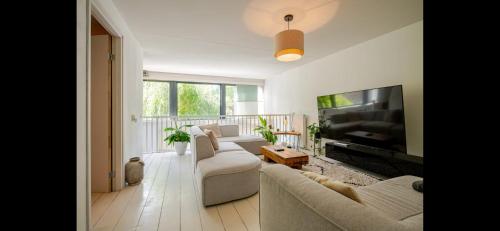 a living room with a couch and a flat screen tv at Spacious 3-Bedroom Apartment Amsterdam West - by Peter in Amsterdam