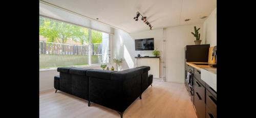 a living room with a couch and a large window at Spacious 3-Bedroom Apartment Amsterdam West - by Peter in Amsterdam