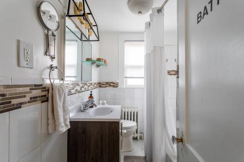 a bathroom with a sink and a toilet and a mirror at Bella room near downtown Train I-95 & beaches in Stamford