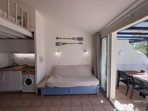 une petite chambre avec un lit et une cuisine dans l'établissement Charmant appartement baie Saint Tropez 6 personnes, à Grimaud