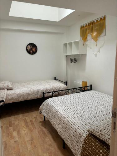 deux lits dans une chambre aux murs blancs et au parquet dans l'établissement Comfortable Apartment in Bondy - 2 Bedrooms, à Bondy