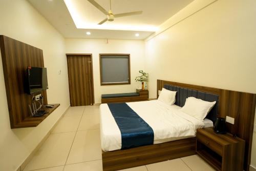 a bedroom with a bed and a flat screen tv at Grand View Residency in Nīleshwar