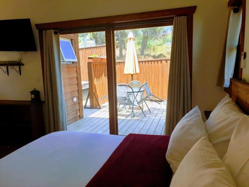 a bedroom with a bed and a patio with a table at BeLev Odem in Odem