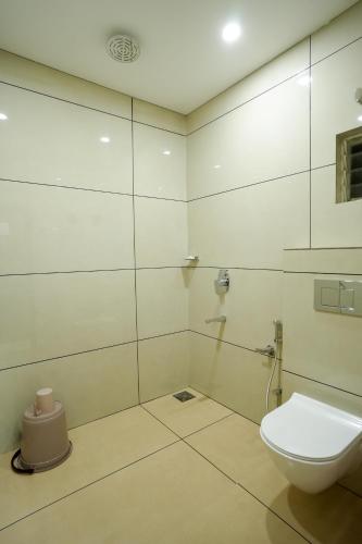 a white bathroom with a toilet and a shower at Grand View Residency in Nīleshwar