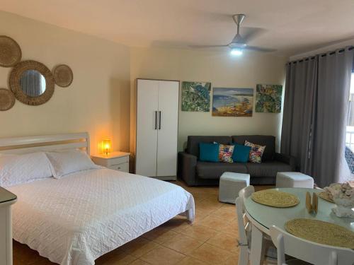 a bedroom with a bed and a couch and a table at Confortable vista al mar in Juan Dolio