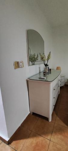 a bathroom with a white vanity with a mirror at Confortable vista al mar in Juan Dolio