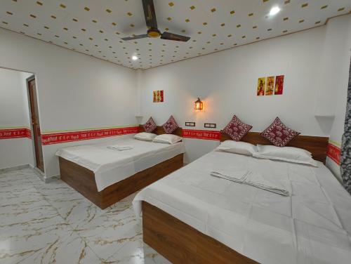 a bedroom with two beds and a ceiling at sundarbon birds view cottage in Japur