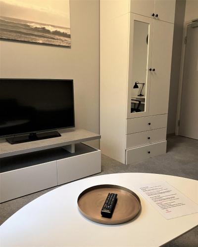 a living room with a tv and a remote control on a table at Forenom Hostel Gothenburg Säve in Gothenburg