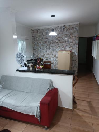 a kitchen with a couch and a counter top at Casa Praia Mongaguá in Mongaguá
