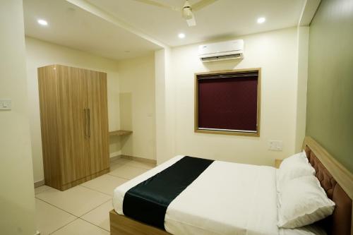 a small bedroom with a bed and a window at Grand View Residency in Nīleshwar