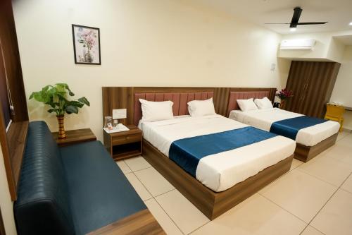 a hotel room with two beds and a couch at Grand View Residency in Nīleshwar