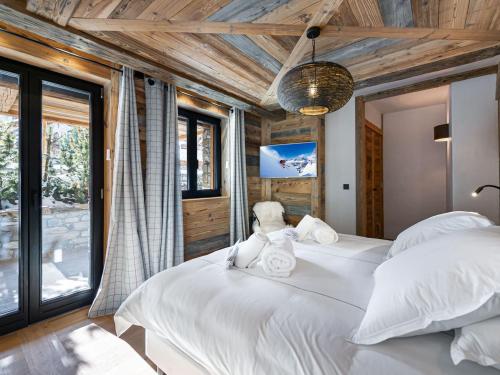 a bedroom with two white beds and a tv at Chalet d'Exception avec Piscine, Hammam et Ascenseur à Val d'Isère, Proche des Pistes - FR-1-567-38 in Val dʼIsère